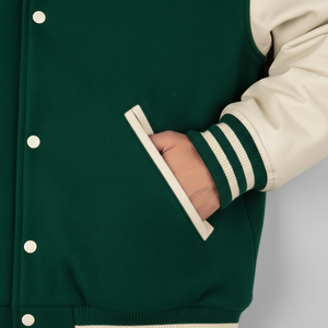 Green varsity jacket with white buttons and cream sleeves on a neutral background