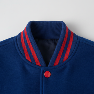 Close-up of a blue jacket with red stripes and button on a light gray background