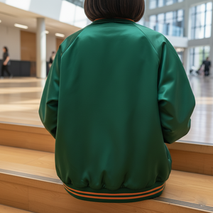 Person wearing a green jacket sitting on wooden steps indoors