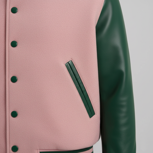 Pink varsity jacket with green accents on a gray background