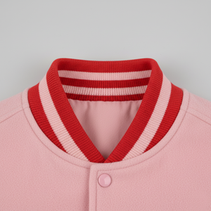 Close-up of a pink jacket with a red and white striped collar on a gray background 