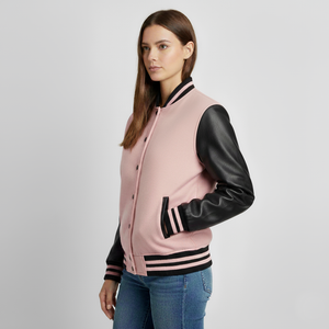 Woman wearing a pink varsity jacket with black sleeves on a light gray background