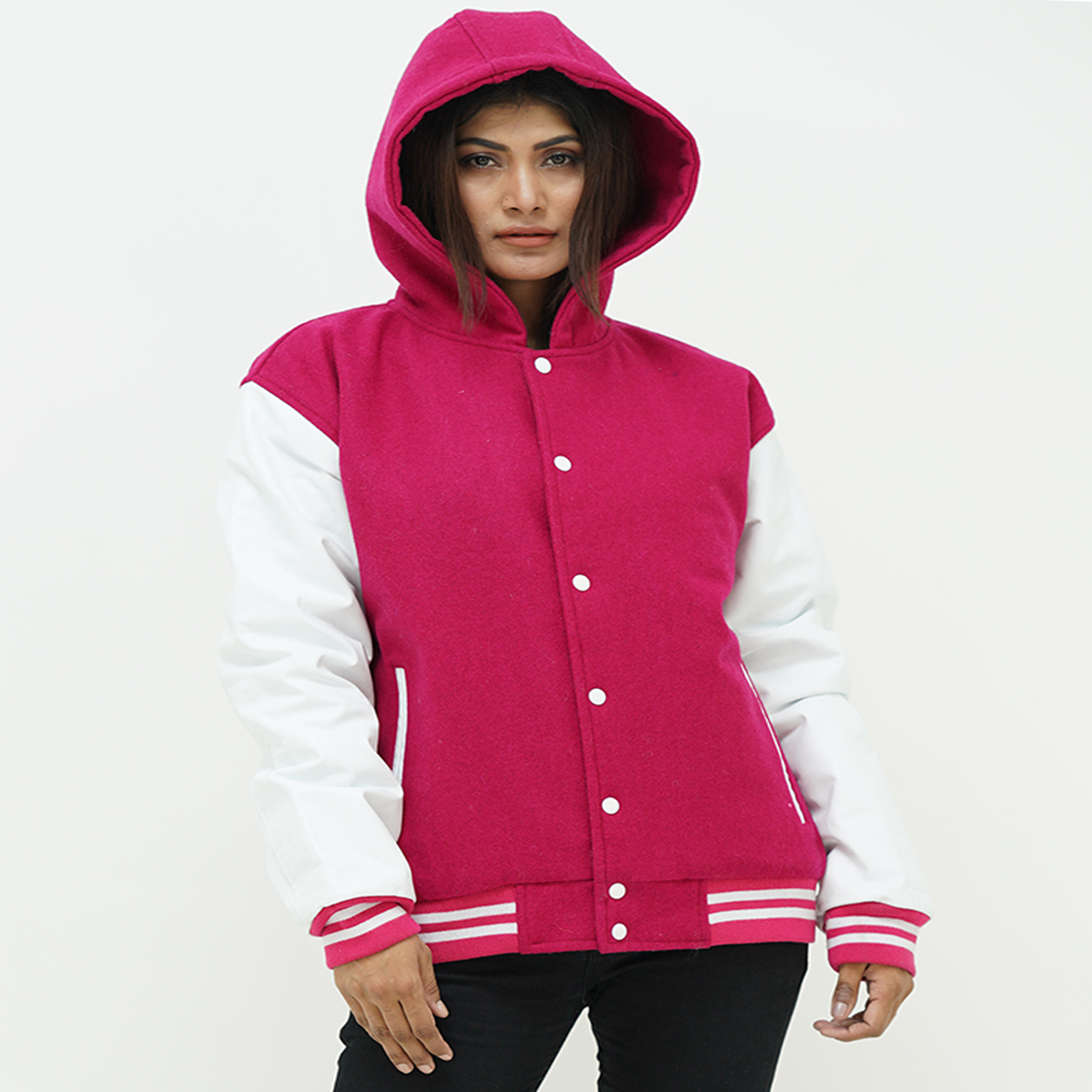 Side profile of girls pink varsity hoodie featuring white leather raglan sleeves and striped ribbed cuffs with drawstring hood