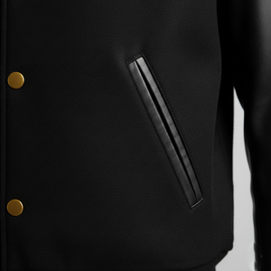 Black jacket with gold buttons and a black patch on a gray background