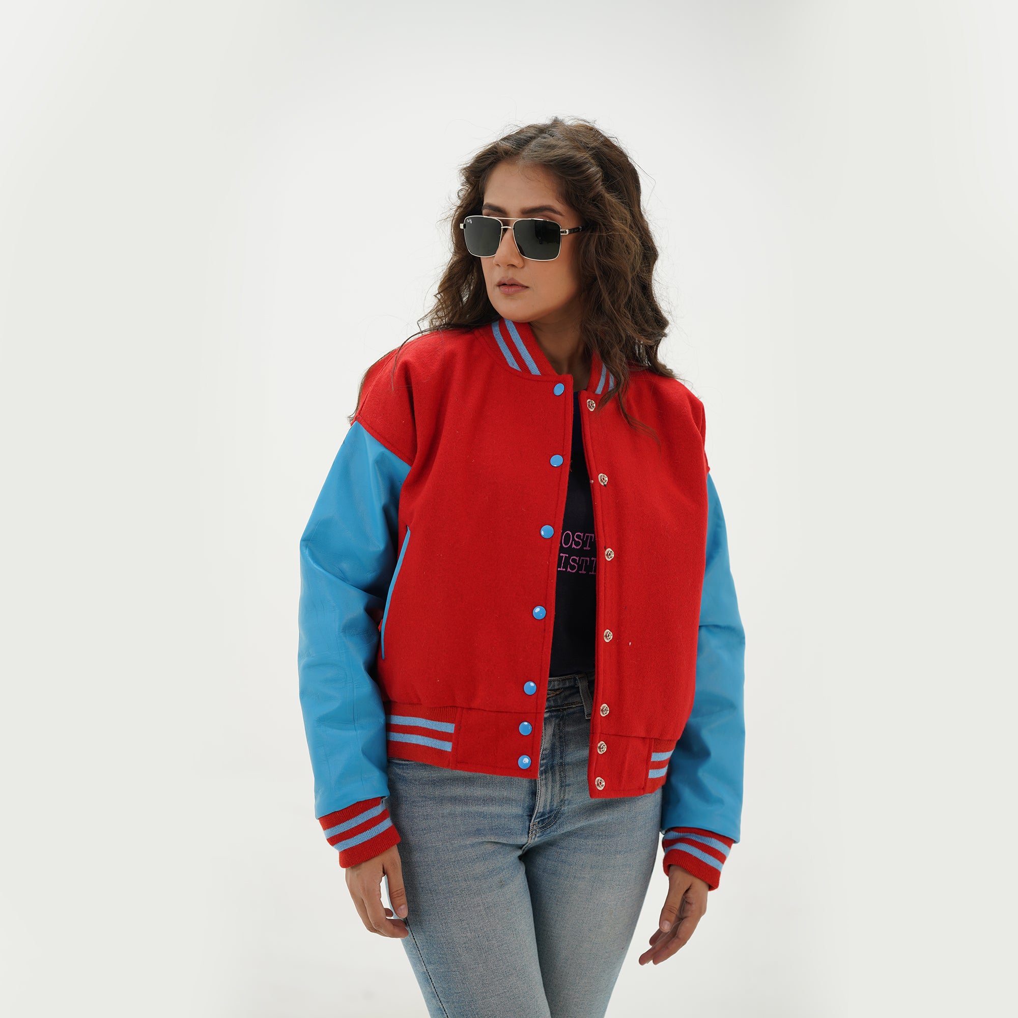 Close-up detail of red and sky blue varsity jacket featuring red wool and sky blue leather sleeve junction with ribbed collar trim
