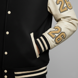 Black and beige varsity jacket with number 26 on a gray background