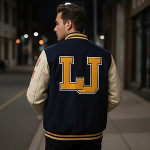 Person wearing a navy blue letterman jacket with 'LJ' on the back, standing on a city street at night.