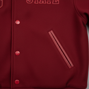 Close-up of a red varsity jacket with buttons and a pocket.