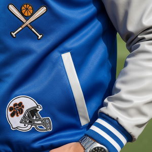 Blue jacket with sports-themed patches and a person wearing a watch.