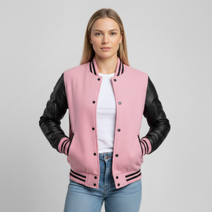 Person wearing a pink varsity jacket with black sleeves on a gray background
