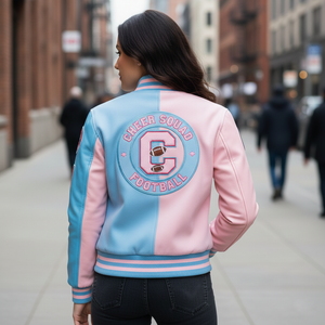 Person wearing a pink and blue 'Cheer Squad Football' jacket on a city street.