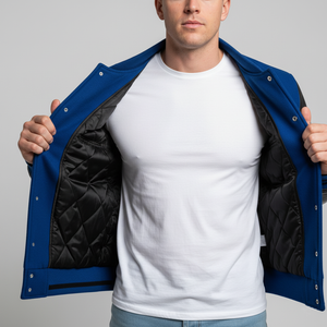 Person wearing a blue jacket with black quilted lining, white t-shirt, and light blue jeans on a gray background