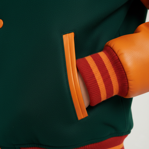 Close-up of a green jacket with orange accents and a striped glove.