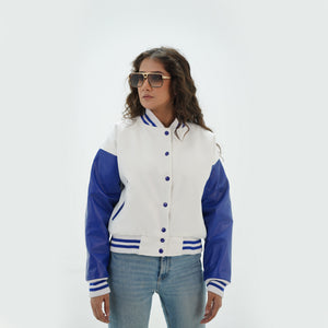Close-up detail of white and blue crop top varsity jacket featuring white wool and blue leather sleeve junction with ribbed collar trim