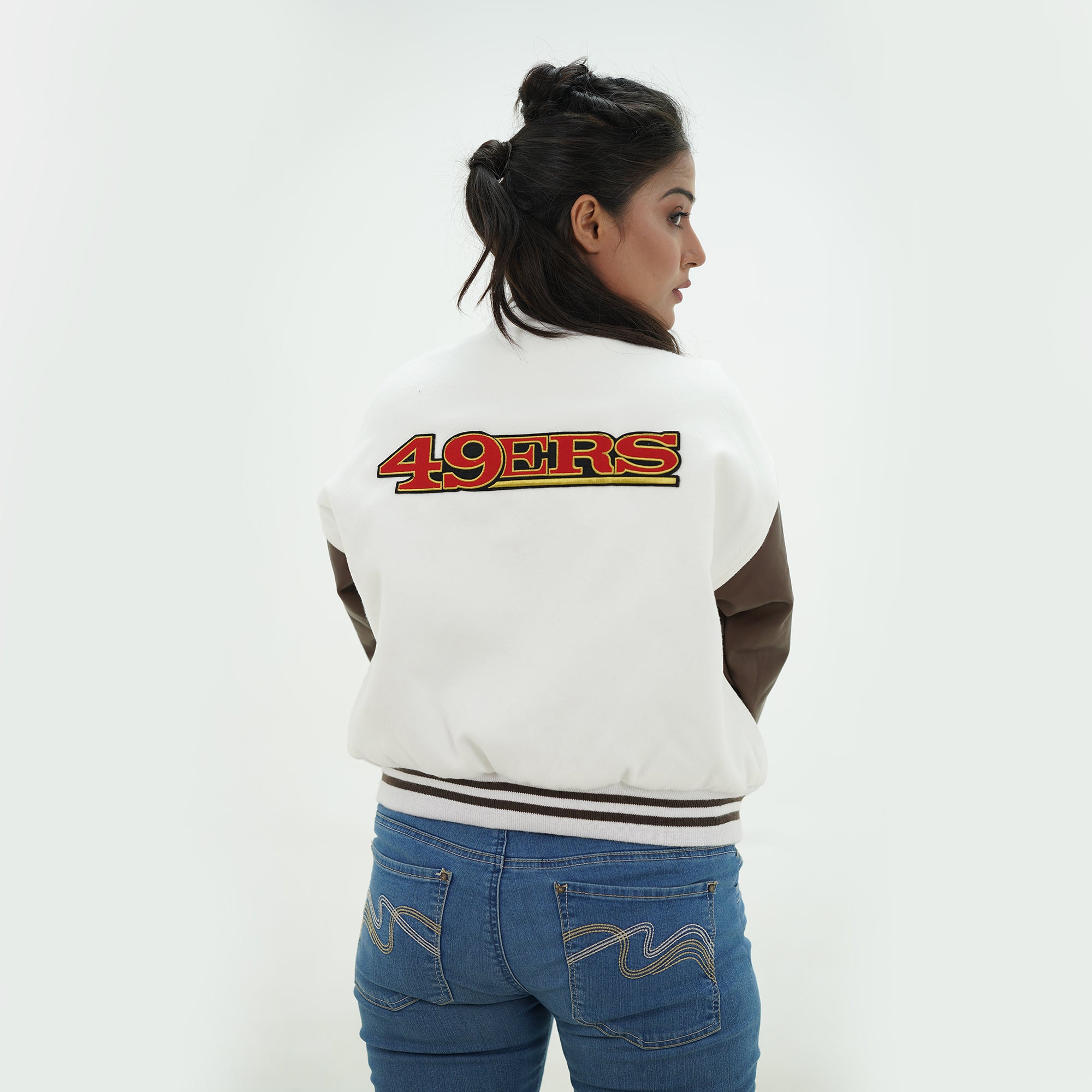 Side profile of women 49ers varsity jacket showcasing chocolate leather arms and premium wool body back for female football fans