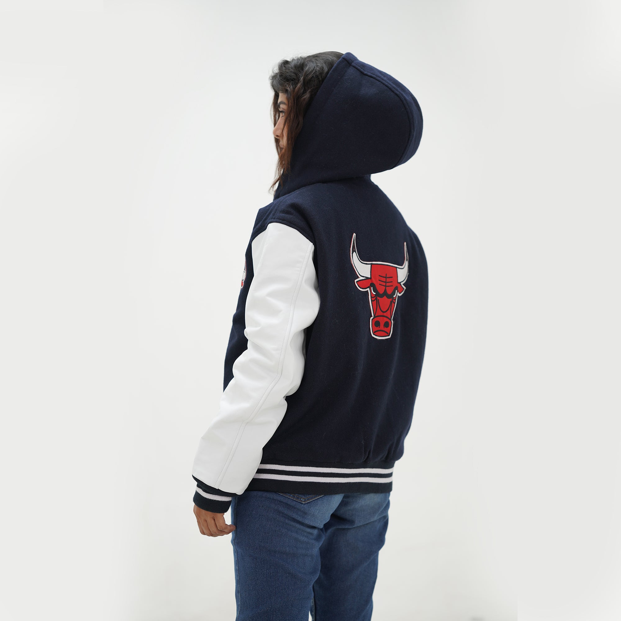 Three quarter angle of women Chicago Bulls hooded jacket highlighting premium wool body and genuine leather sleeves for female fans