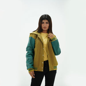 Three-quarter angle of women's camel varsity jacket with hood and green leather sleeves showing premium wool construction