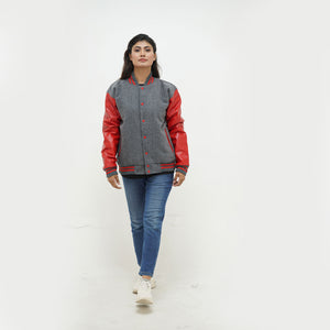 Three-quarter view of women's grey and red letterman jacket highlighting snap buttons, side pockets, and sophisticated color contrast