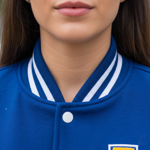 Close-up of a person wearing a blue varsity jacket with white stripes on the collar.