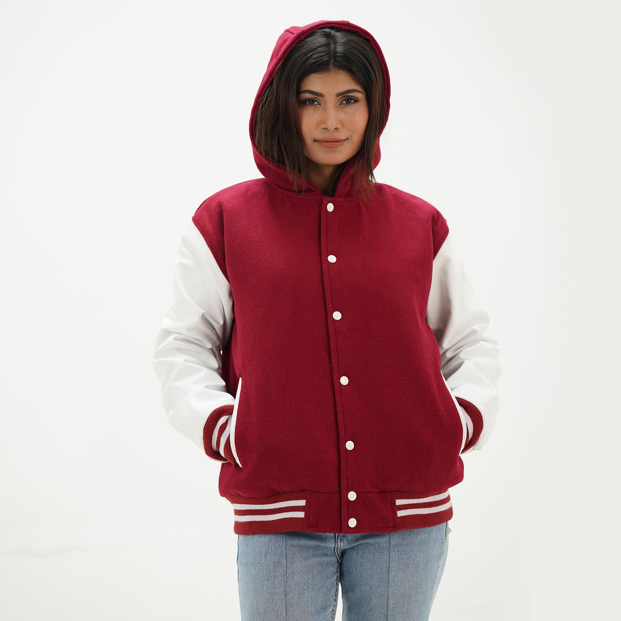 Side angle of women's magenta hoodie letterman jacket showing white leather sleeve detail, attached hood, ribbed cuffs, and feminine fit