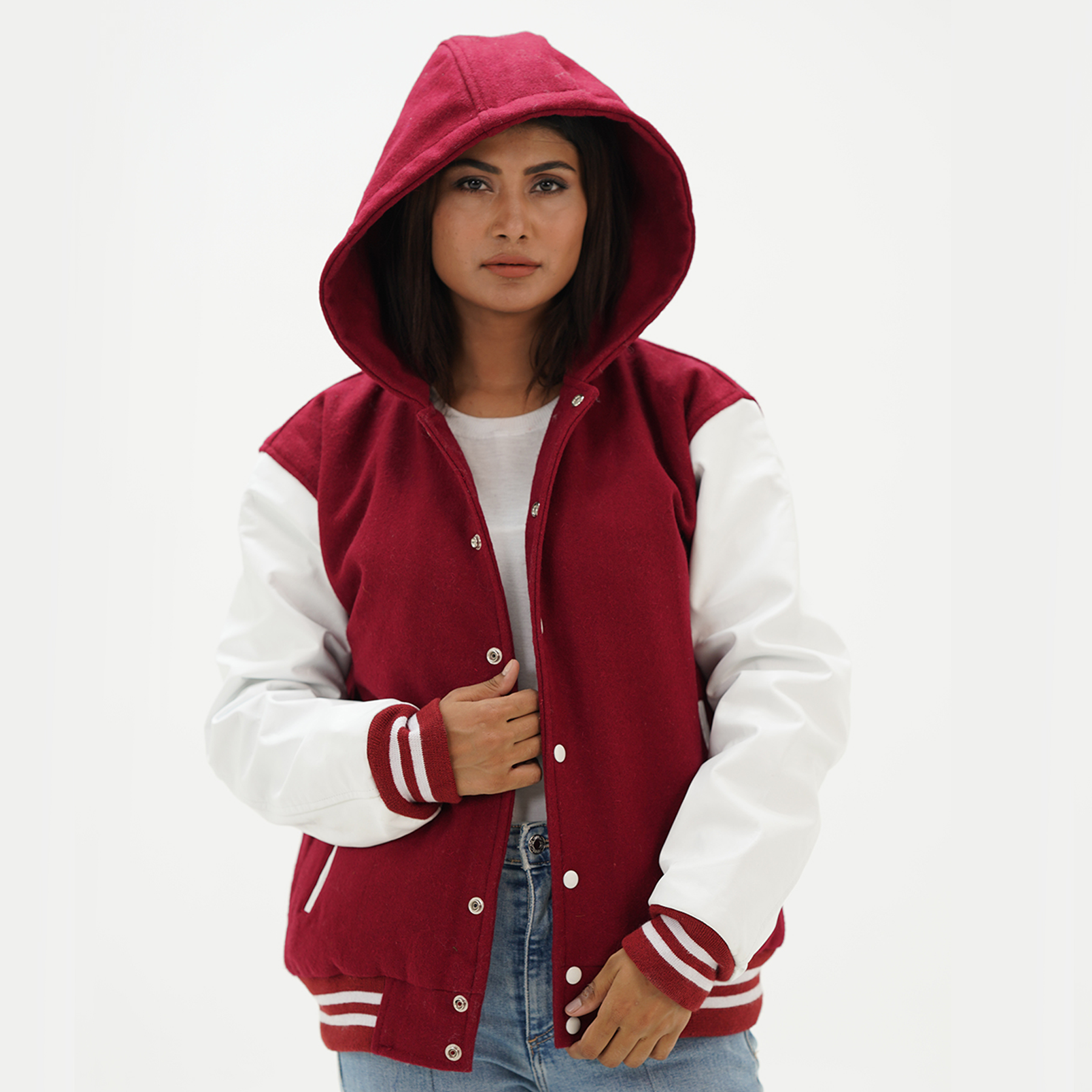Women's magenta varsity hoodie jacket front view with magenta wool body, white leather sleeves, attached hood, snap button closure, and ribbed collar