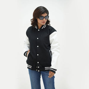 Women's monochrome varsity jacket three-quarter view - highlighting feminine tailored fit with white leather sleeves and black wool body