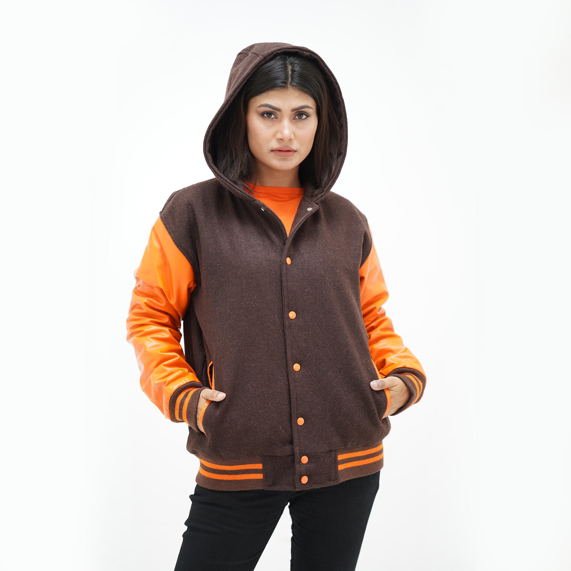 Three-quarter angle of women's mustard letterman jacket with hood showing old gold leather sleeves and ribbed waistband