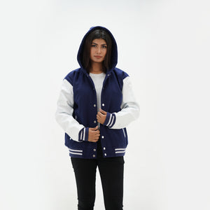 Three-quarter view of women's navy hooded letterman jacket with white leather sleeves showing premium wool body construction