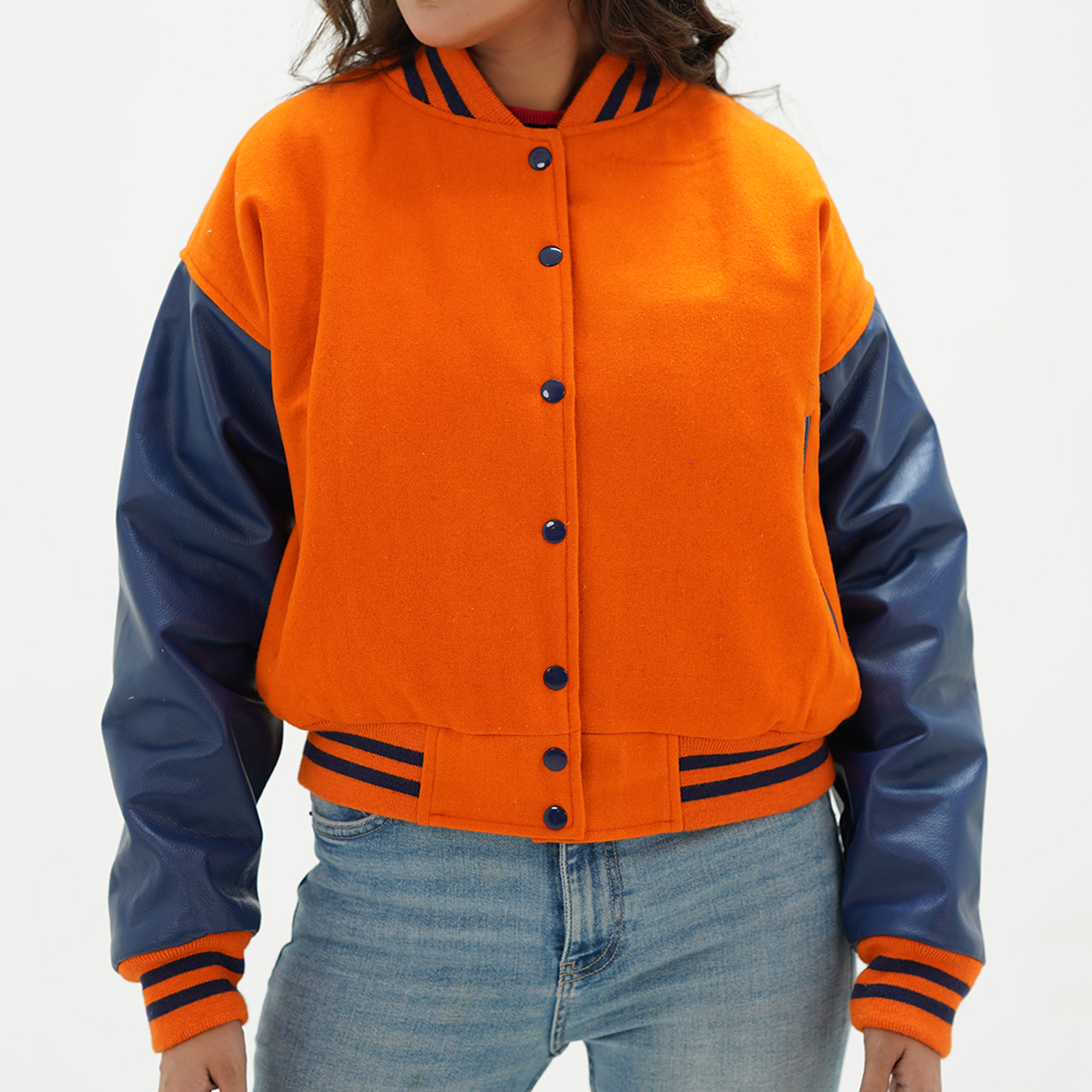 Women's orange and java plum cropped jacket front view with orange wool body, java plum leather sleeves, and cropped ribbed waistband