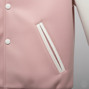Close-up of a pink jacket with white buttons and trim on a light gray background 