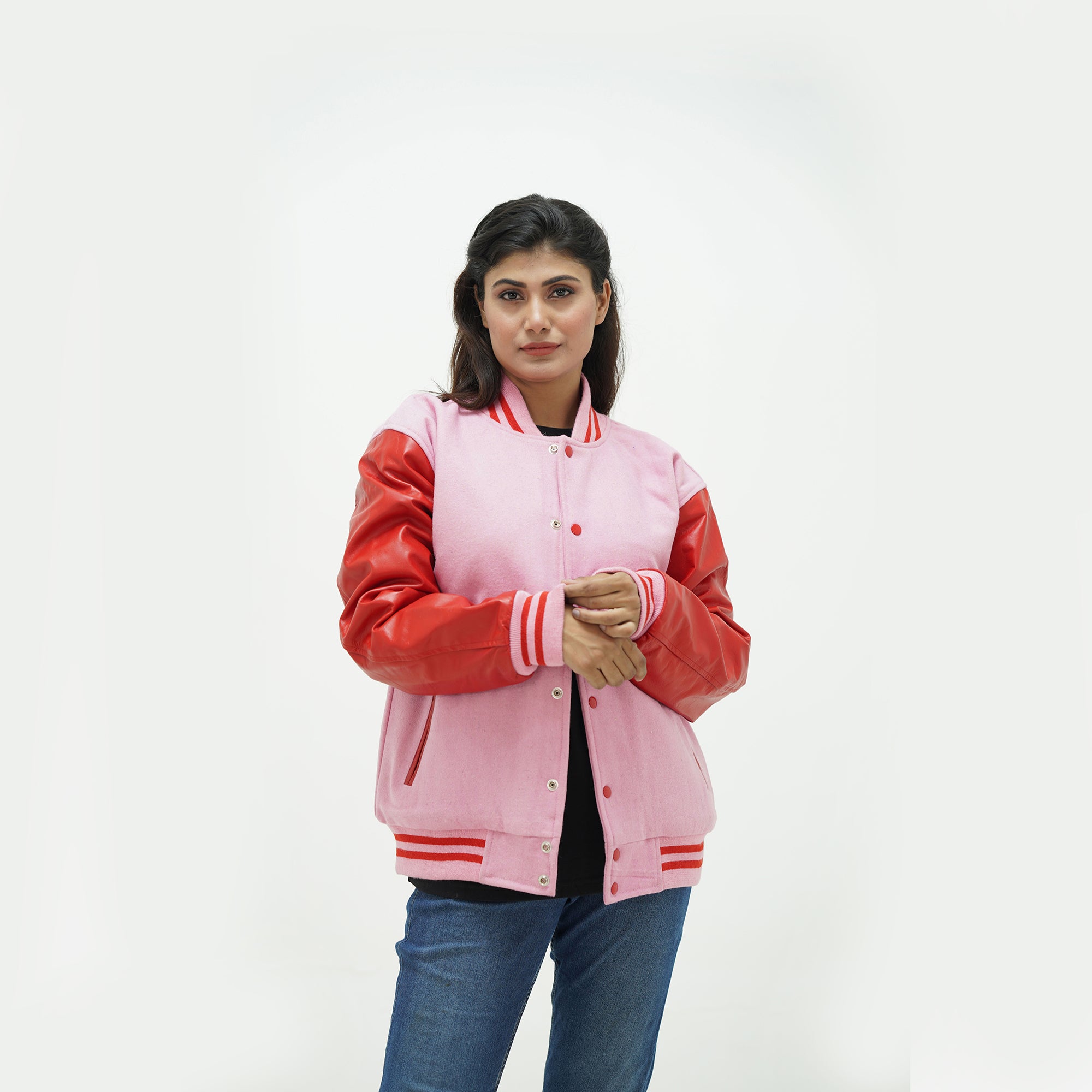 Three-quarter angle of women's red and pink varsity jacket highlighting snap buttons, pocket details, and wool-leather contrast