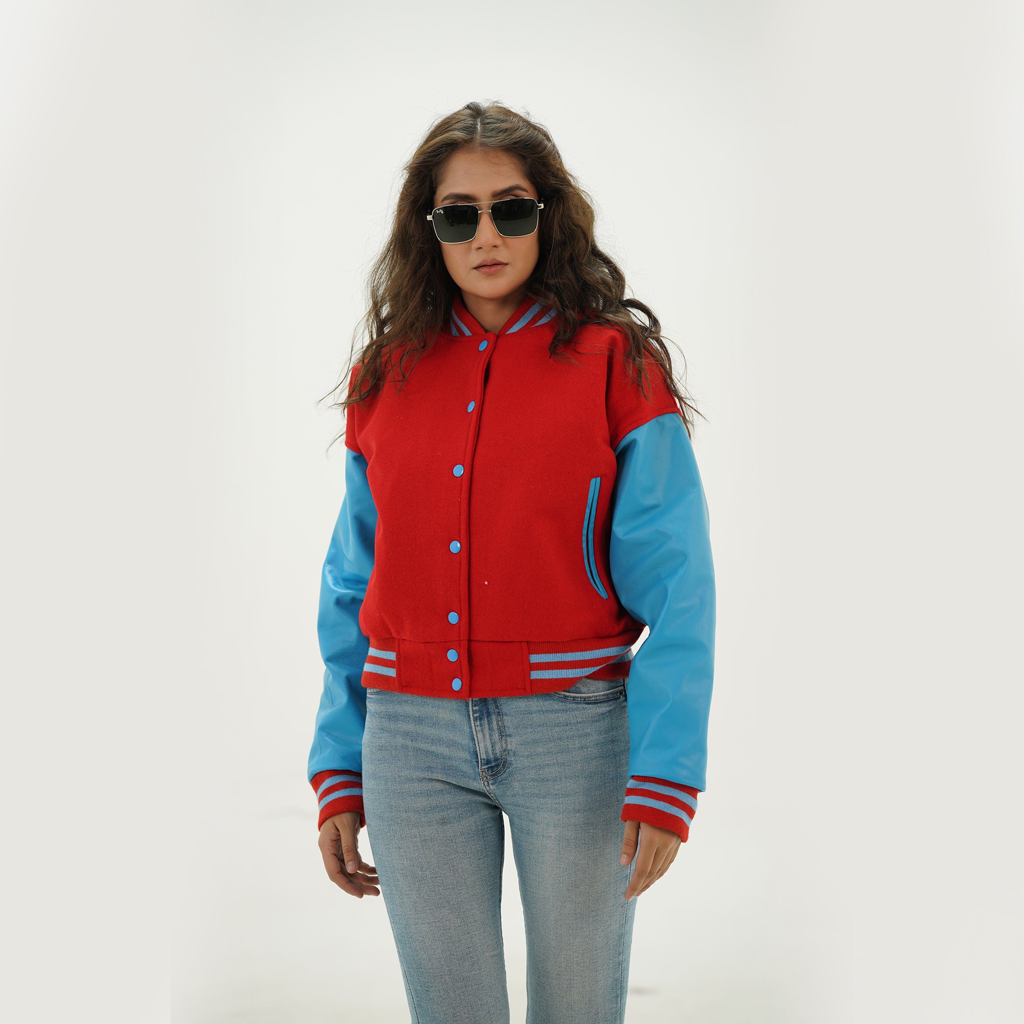 Side profile of women's red and sky blue letterman jacket showing sky blue leather sleeve construction, ribbed cuffs, and tailored feminine fit