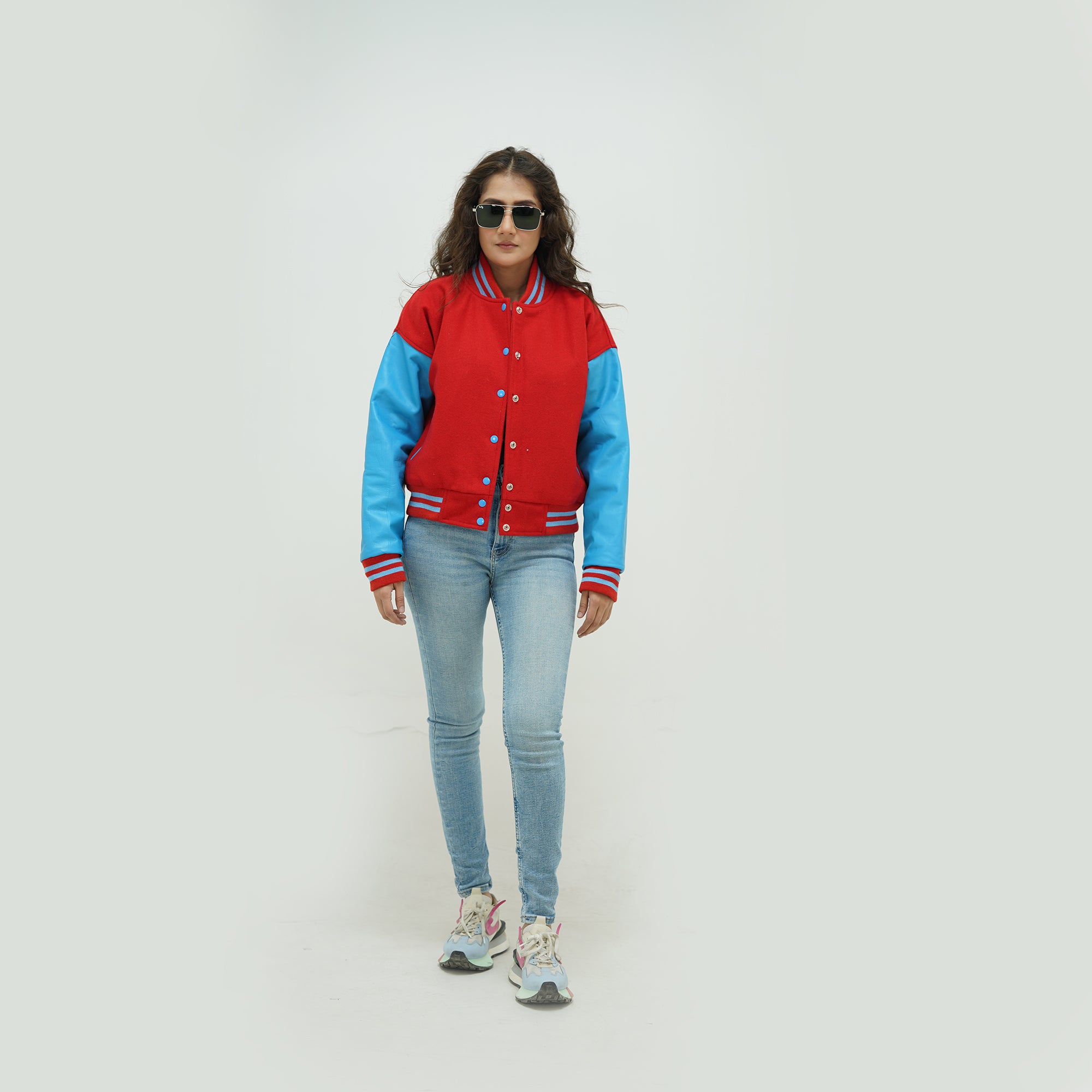 Full display of women's red and sky blue varsity jacket showing complete fit, premium materials, and striking red-sky blue varsity styling