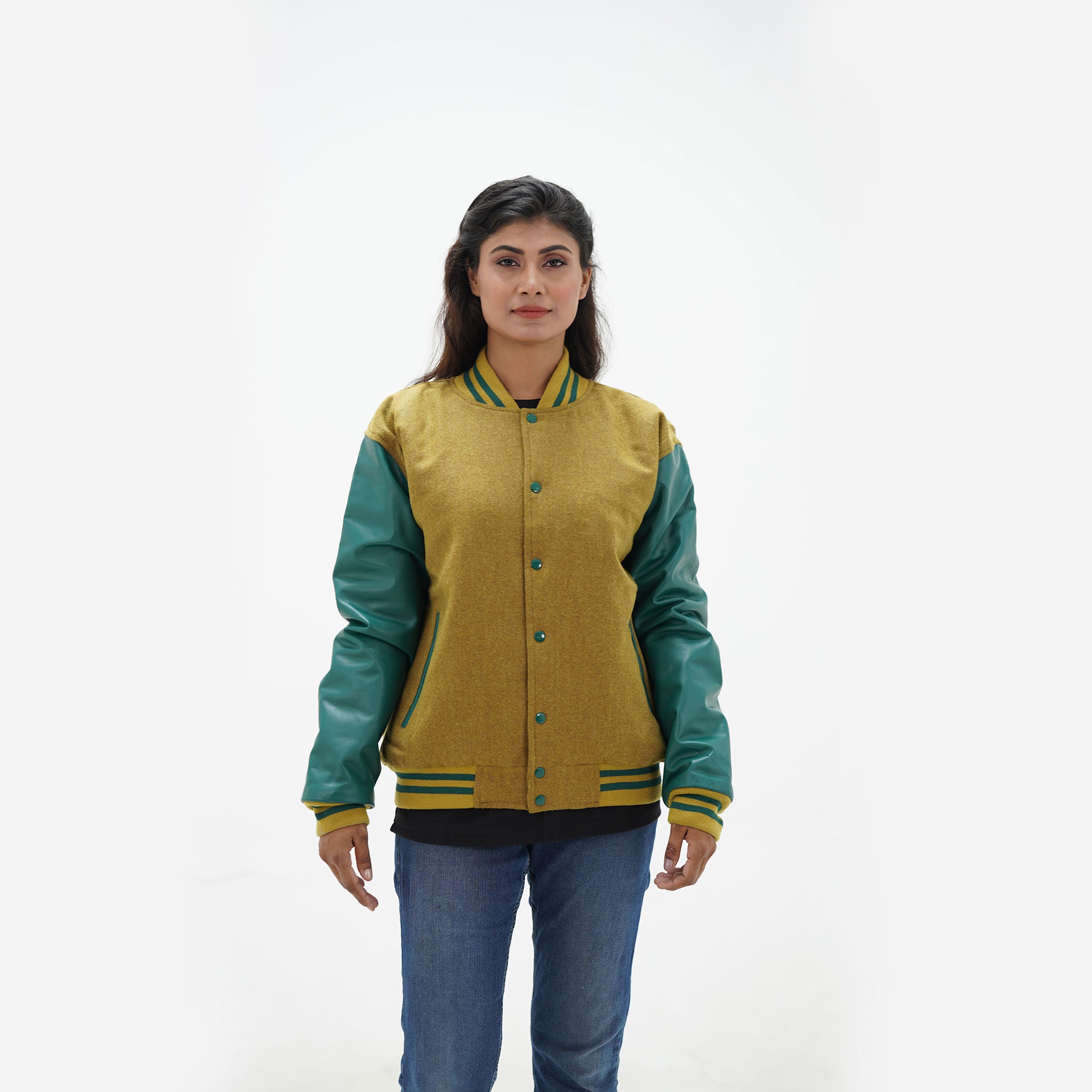 Three-quarter view of women's camel varsity jacket with green leather sleeves highlighting snap buttons, pocket placement, and wool texture