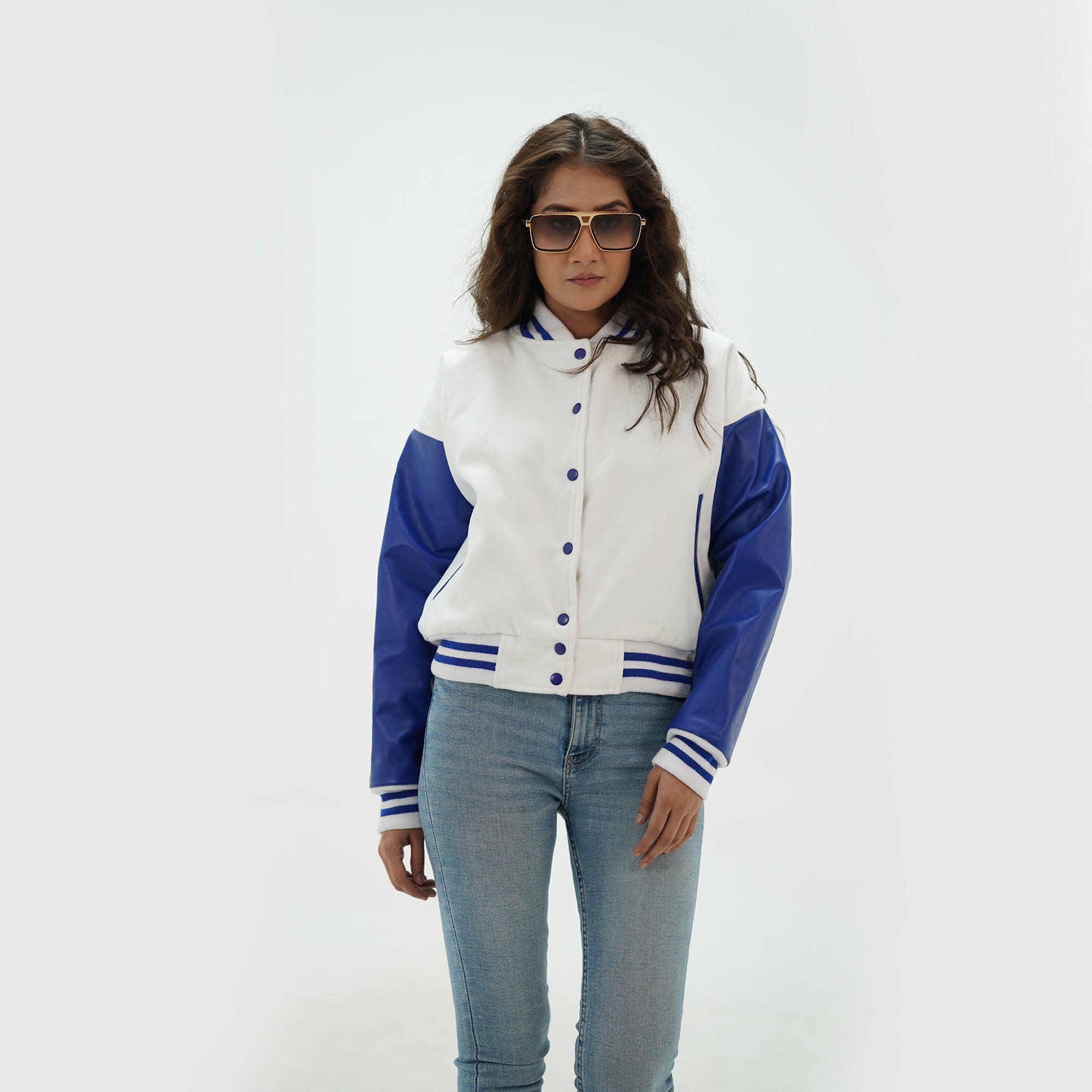 Detail shot of women's white and blue crop top varsity jacket displaying ribbed trim accents and classic modern edge styling