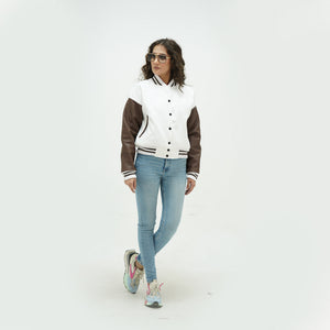 Side profile of women's white and chocolate brown letterman jacket showing chocolate brown leather sleeve construction, ribbed cuffs, and tailored feminine fit