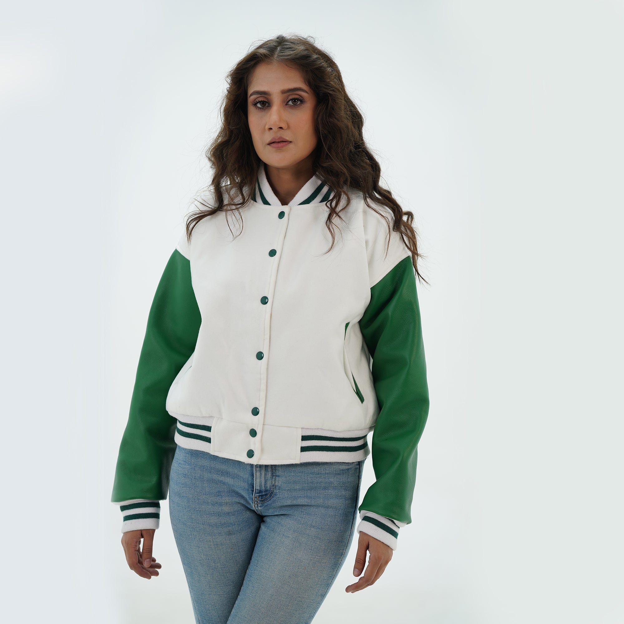 Side profile of women's white and green letterman jacket showing green leather sleeve construction, ribbed cuffs, and tailored feminine fit
