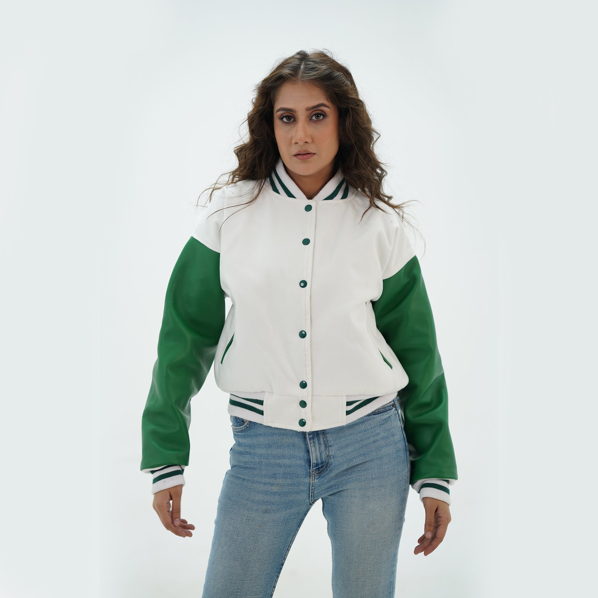 Three-quarter angle of women's white and green varsity jacket highlighting snap buttons, side pockets, and fresh white-green color scheme
