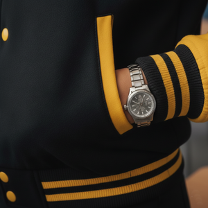 Person wearing a silver watch with a black and yellow striped sleeve.